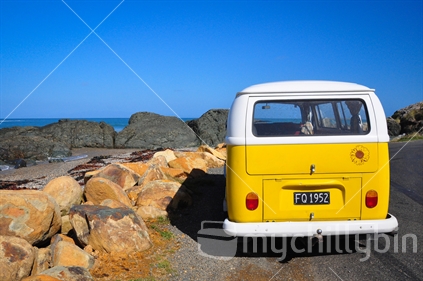 Yellow Volkswagen camper parked at the beach in Southland