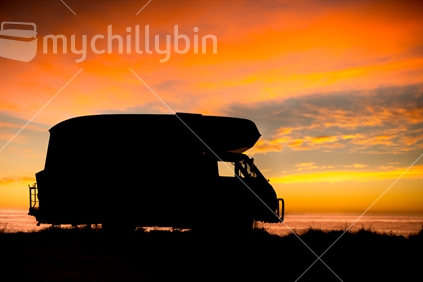 1974 Retro Campervan sillouetted by the Sunrise on the waters edge in Kaikoura