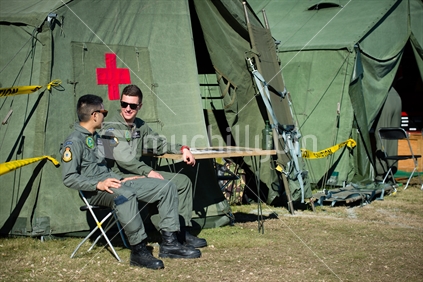 Two young RNZAF pilots sitting outside Airforce medical first aid tent at training camp in Nelson