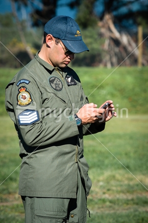 Young RNZAF pilot using cellphone at Airforce training Camp in Nelson
