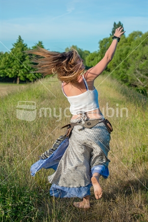 Young woman dancing in the long grass in nature