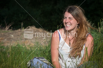 Young woman sitting in long grass