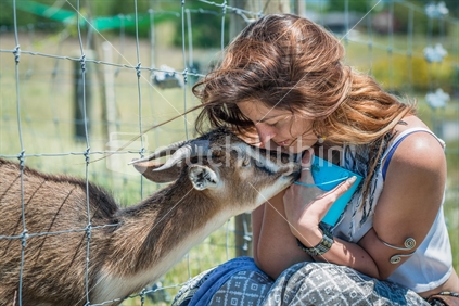 Young woman interacting with kid at Farm Park in Tasman district