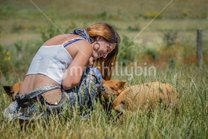 Beautiful young woman interacting piglets at animal  farm in Tasman