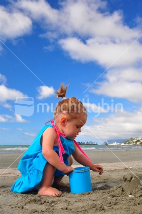 Girl making sandcastles at a New Zealand beach