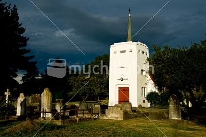 The last rays of sunshine reflecting off the white tower of this little church looked all the more dramatic under a dark NorWest sky, New Zealand