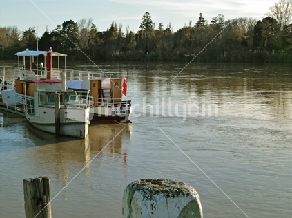 Wharf and boats on the Whanganui river, New Zealand.