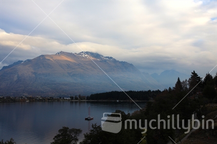 Storm rolling in over lake Whakatipu in Queenstown at sunset.