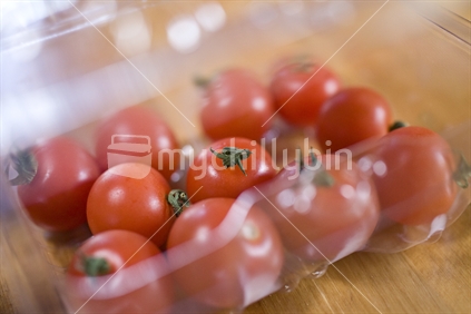 A plastic container of ripe cherry tomatoes