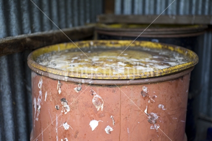 A rusty tin drum covered in bird droppings