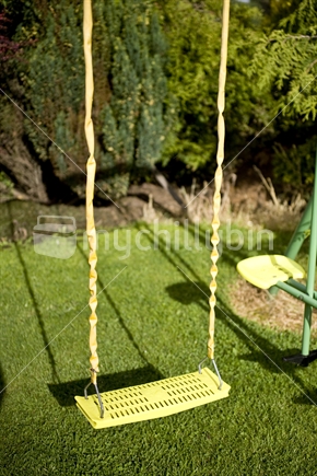 A swingset hangs in a garden