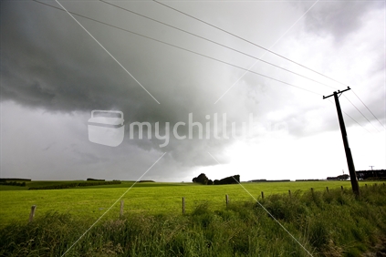 Approaching storm clouds over farmland in southland