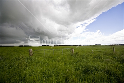 Approaching storm clouds over farmland in southland
