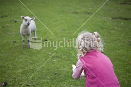 A young girl with milk for her pet lamb