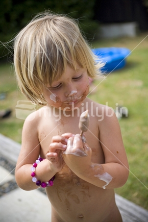 Young blonde child enjoying a summer ice cream