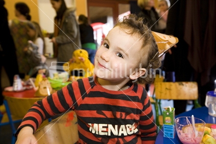A cheeky young boy at a birthday party