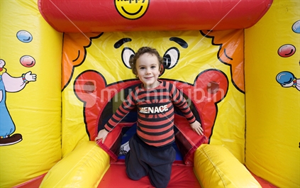 A young boy in a bouncy castle at a birthday party