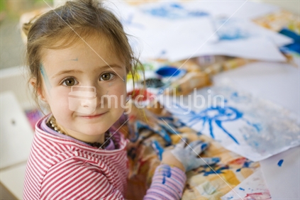 A young girl fingerpainting