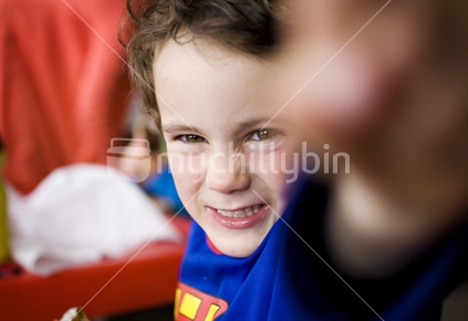 A young boy playing in a superman top