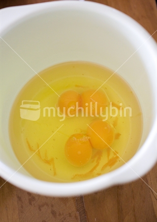 Two double yolked eggs in a white plastic bowl