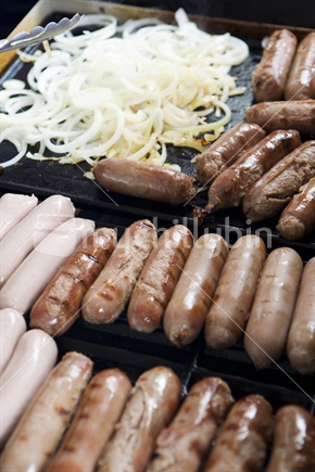 Sausages and onion rings on a BBQ