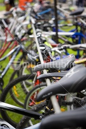 A row of bikes resting on a bike rack