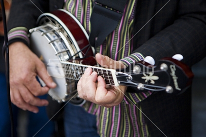 A busker playing his banjo on an Auckland street