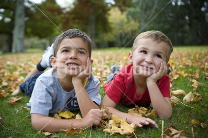 2 brothers lying in autumn leaves