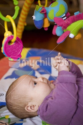 A baby lying on a playmat