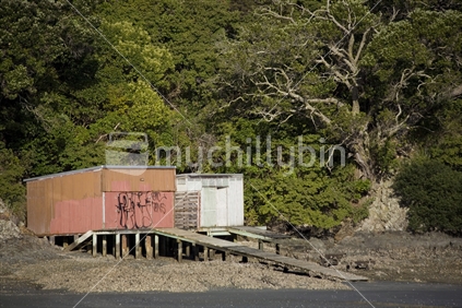 Old boat sheds on Oneroa beach at low tide, Waiheke Island, New Zealand