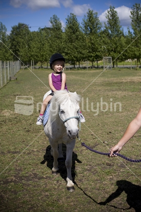 A young girl enjoying a summer pony ride 
