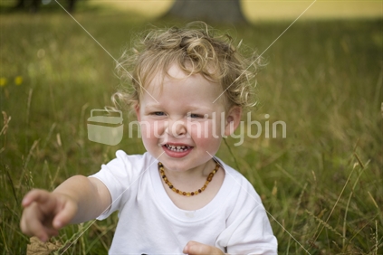 A young blonde boy in a field of long late summer grass