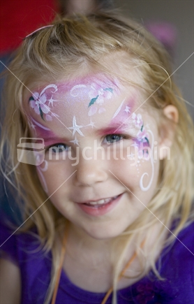 A beautiful blue eyed blonde girl with fairy face paint