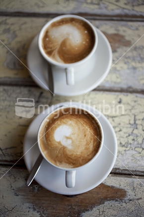 2 flatwhites on an old cafe table
