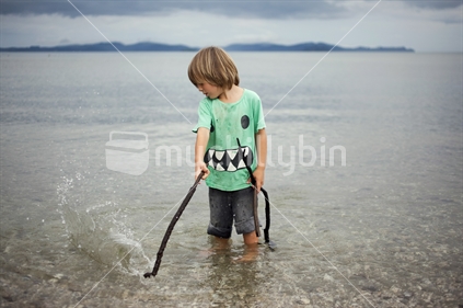Young boy splashing in calm water