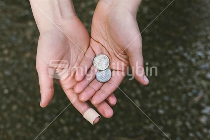 Open hands with plaster and coins