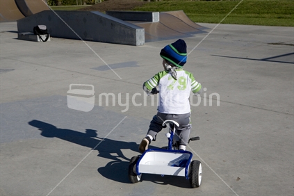 young boy playing on his trike