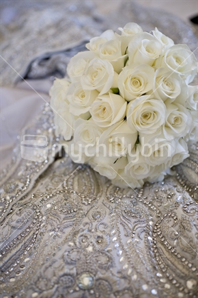 Bouquet of white roses on a ornate jeweled gown