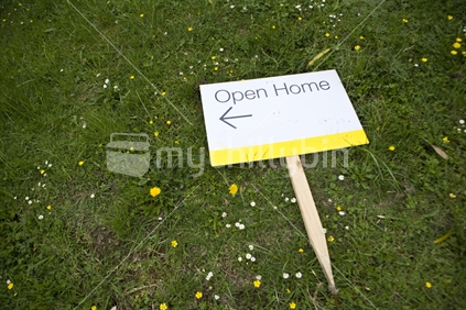 Open home sign lying on the ground