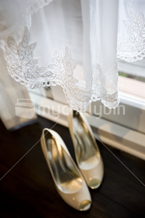 Lacy hem of a wedding dress and shoes