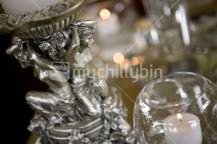 Detail of candle holder with diaphanous naked ladies