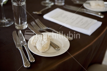 Place setting for dinner with menu and bread