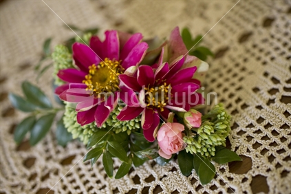 Dark pink corsage on a lace cloth