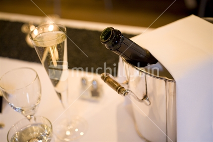 Champagne bottle and glass at reception table