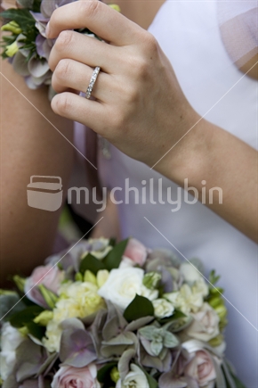 A brides detail with ring and flowers