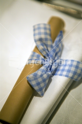 Rolled up menu wrapped in blue gingham
