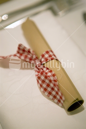Rolled up menu wrapped in red gingham
