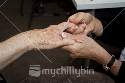 A older woman receives a therapeutic hand massage. 