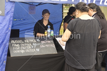 Women buying fritters at a fast food stall at Otara markets. 