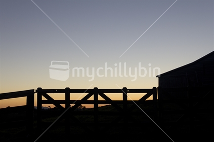 Fence and shed silhouette at dawn.